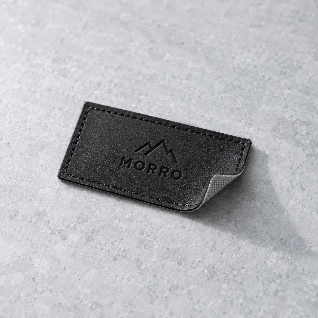 Debossed synthetic leather patch with textile backing